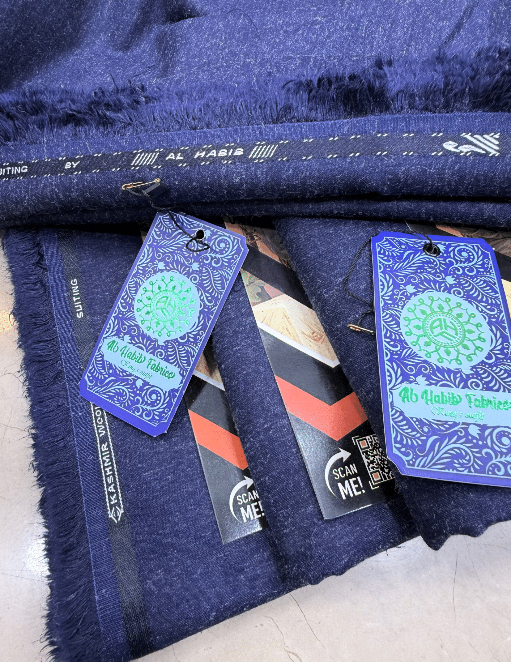 Navy fabric with Al Habib Tablet tags on a white background**AlHabibFabrics, AlHabibWinter, King'sOutfit, TopClassChoice, AlHabib, KashmirWool, WoolFabric, PremiumWool, SoftWool, WarmFabric, UnstitchedWool, SuitingWool, Men'sSuiting, UnstitchedFabric, ShalwarKameezFabric, KurtaShalwarFabric, Men'sDressMaterial, PremiumSuit, LuxuryMenswear, ElegantFabric, FormalWearMen, BestWinterFabric, NavyBlue, CharcoalGrey, DarkBrown, DeepBlue, MaroonFabric, GreySuit, PlainColors, PakistaniFabric, Menswear, WinterWearPak
