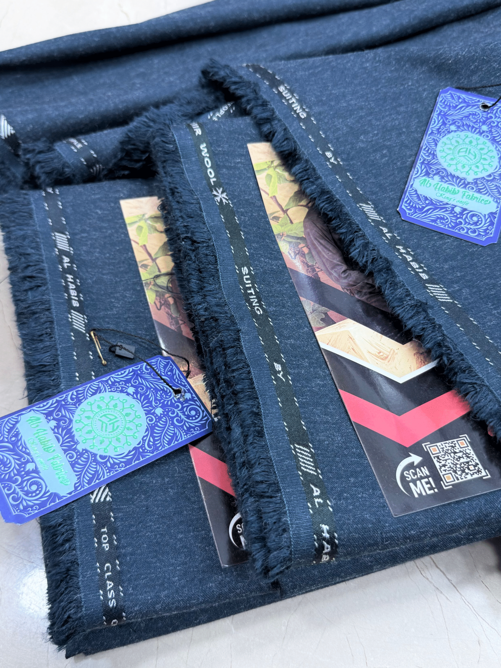 Dark blue fabric with tags and labels on a white surface**AlHabibFabrics, AlHabibWinter, King'sOutfit, TopClassChoice, AlHabib, KashmirWool, WoolFabric, PremiumWool, SoftWool, WarmFabric, UnstitchedWool, SuitingWool, Men'sSuiting, UnstitchedFabric, ShalwarKameezFabric, KurtaShalwarFabric, Men'sDressMaterial, PremiumSuit, LuxuryMenswear, ElegantFabric, FormalWearMen, BestWinterFabric, NavyBlue, CharcoalGrey, DarkBrown, DeepBlue, MaroonFabric, GreySuit, PlainColors, PakistaniFabric, Menswear, WinterWearPakist