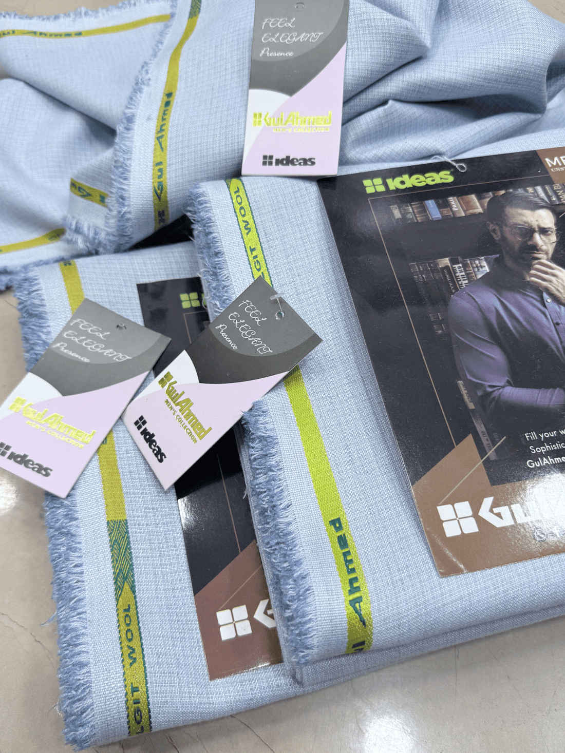 Set of folded men's shirts with Gul Ahmed branding on a tiled floor.GulAhmedMen,UnstitchedFabric,MensSuiting,GilgitWool,IdeasMens,PremiumFabricPakistan,WinterSuiting,GulAhmedSuits,SophisticatedOutfits,ShalwarKameezFabric, GulAhmedFabric,IdeasMen,UnstitchedSuits,MenWoolFabric,WinterCollection,MensDressMaterial,UnstitchedWoolSuit,GulAhmedOnline,MensEasternWear,PakistaniSuits, LuxuryMensFabric,FineWool,GilgitWoolSuiting,ElegantPresence,ClassicMenswear,UnstitchedWinter,FormalSuiting,GentlemanFabric,GulAhmedNewC