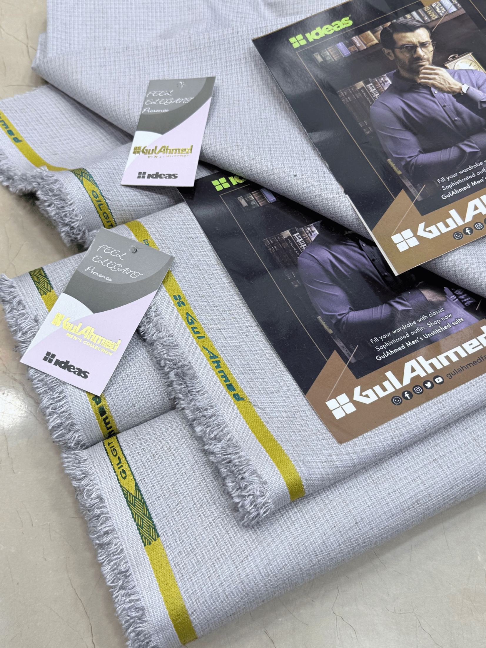 Gray fabric with yellow stripes and Gul Ahmed branding, displayed on a flat surface.GulAhmedMen,UnstitchedFabric,MensSuiting,GilgitWool,IdeasMens,PremiumFabricPakistan,WinterSuiting,GulAhmedSuits,SophisticatedOutfits,ShalwarKameezFabric, GulAhmedFabric,IdeasMen,UnstitchedSuits,MenWoolFabric,WinterCollection,MensDressMaterial,UnstitchedWoolSuit,GulAhmedOnline,MensEasternWear,PakistaniSuits, LuxuryMensFabric,FineWool,GilgitWoolSuiting,ElegantPresence,ClassicMenswear,UnstitchedWinter,FormalSuiting,GentlemanFab